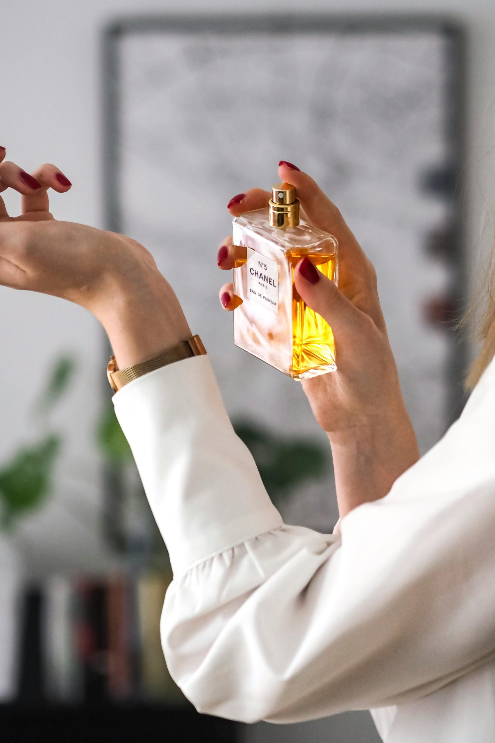 Close-up of a woman applying perfume on her wrist. Elegant and sophisticated.